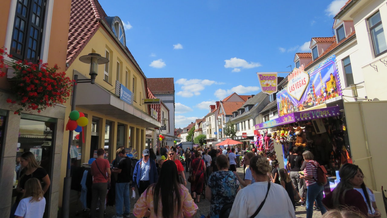 Viele Menschen laufenin der Achimer Innenstadt über das  Kinderstadtfest. Auf dem Weg sind Fest-Buden aufgebaut. 