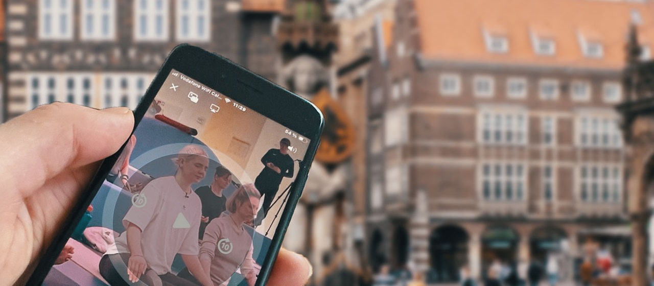 Handy vor Hintergrund Marktplatz Bremen